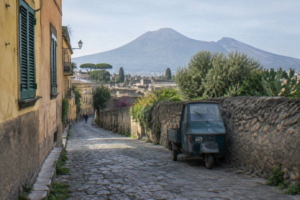 Quiet street in Ercolano with Vesuvius rising above the rooftops in morning light